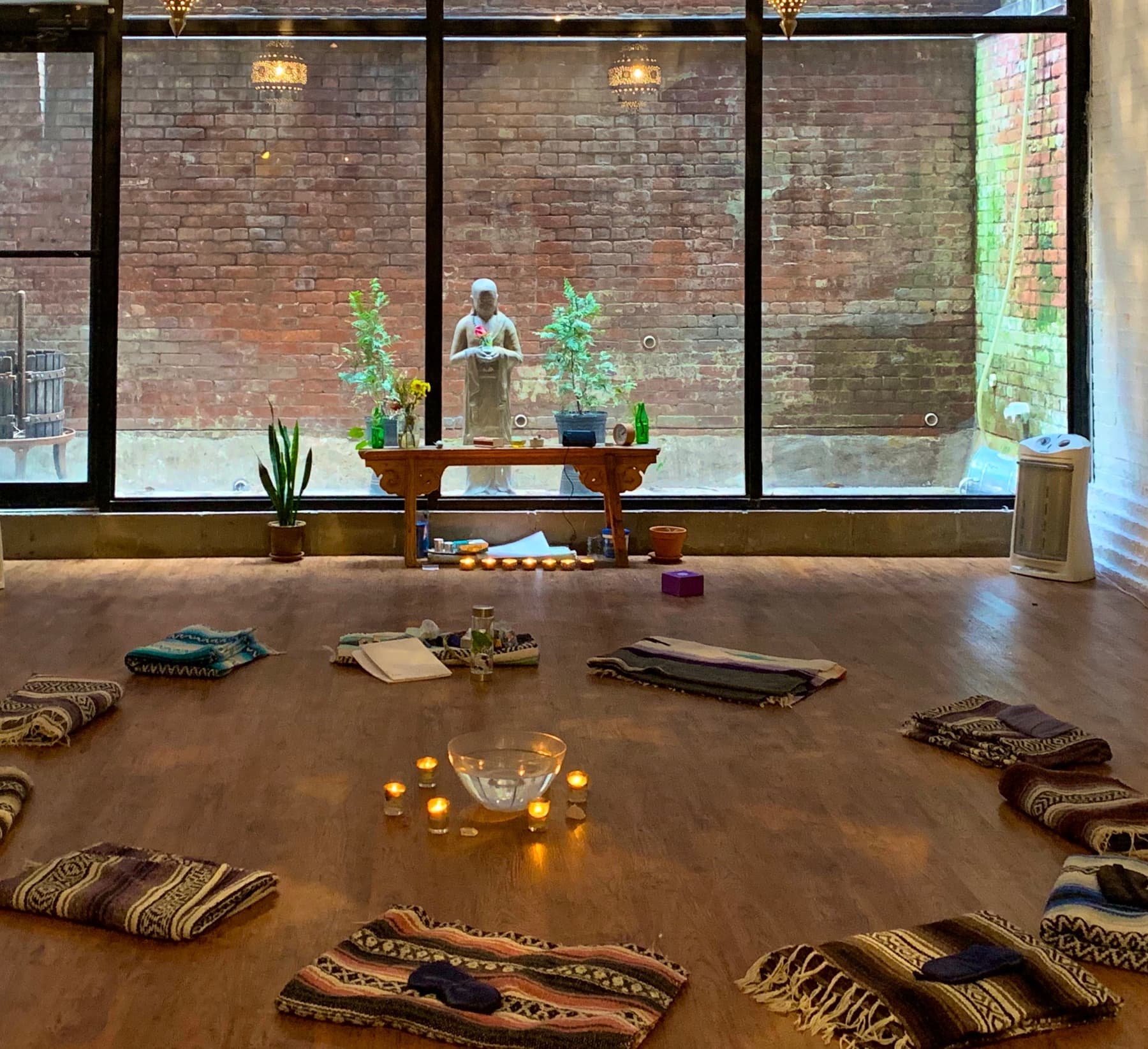 Meditation studio with buddha statue, candles, and meditation mats